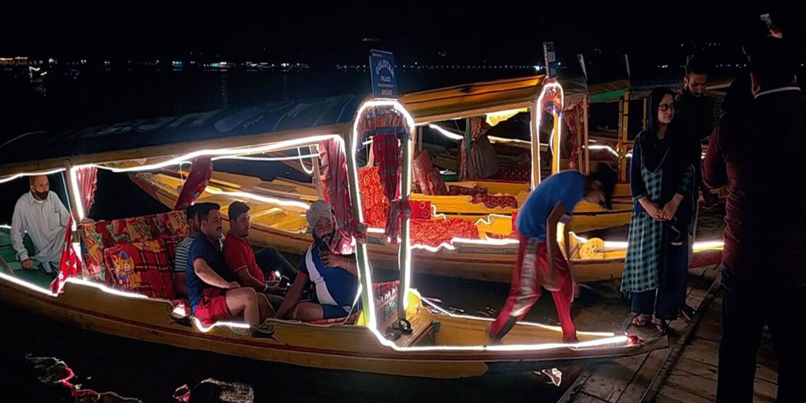 Shikaras “Boats” illuminated with Led lights during the night for tourists enjoying a ride in Dal Lake Srinagar