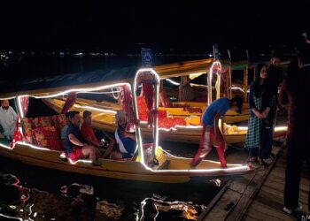 Shikaras “Boats” illuminated with Led lights during the night for tourists enjoying a ride in Dal Lake Srinagar