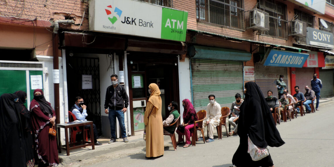 People waiting outside the bank for their turn following SOPs amid strict lockdown in Srinagar to combat the surge in COVID-19 pandemic positive cases in Kashmir valley