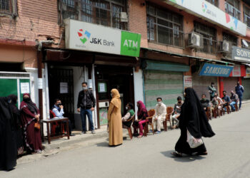 People waiting outside the bank for their turn following SOPs amid strict lockdown in Srinagar to combat the surge in COVID-19 pandemic positive cases in Kashmir valley