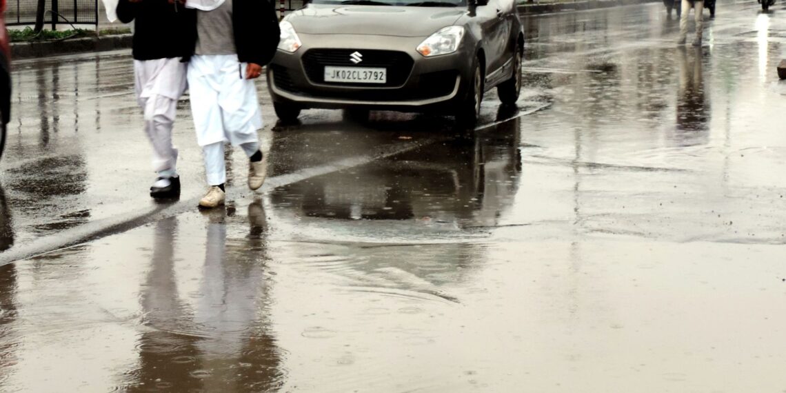 Students walking down the Lal Chowk in Srinagar amid rain fall in Srinagar