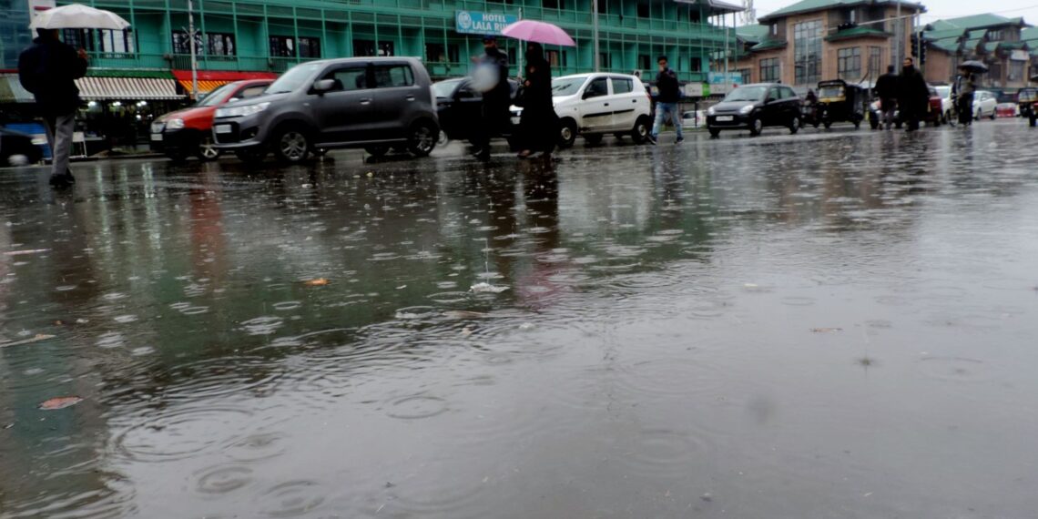 Students walking down the Lal Chowk in Srinagar amid rain fall in Srinagar