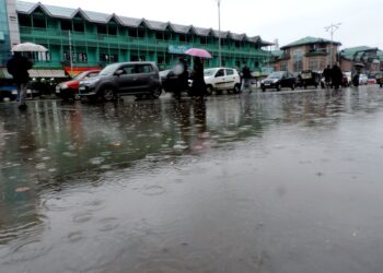 Students walking down the Lal Chowk in Srinagar amid rain fall in Srinagar