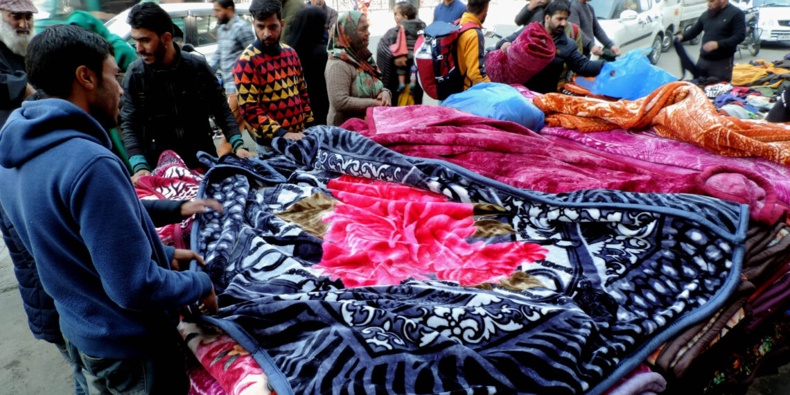 People purchasing warm blankets at Sunday market in Srinagar