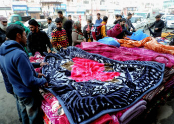 People purchasing warm blankets at Sunday market in Srinagar