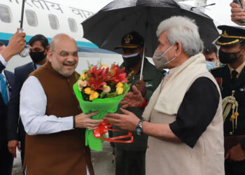 Lt Guv Manoj Sinha welcomes Union Home Minister Amit Shah with a bouquet of flowers on his arrival at Srinagar Int’l Airport-Pic/ Kashmir Horizon