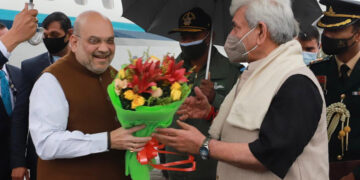 Lt Guv Manoj Sinha welcomes Union Home Minister Amit Shah with a bouquet of flowers on his arrival at Srinagar Int’l Airport-Pic/ Kashmir Horizon