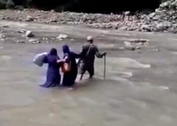 Health Workers cross river to take vaccine too remote area in Rajouri distt