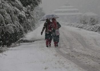 Heavy snowfall disrupts normal life across Kashmir. Two women unfold umbrella to cover their heads on way to their destinations in Srinagar- Pic/Kashmir Horizon
