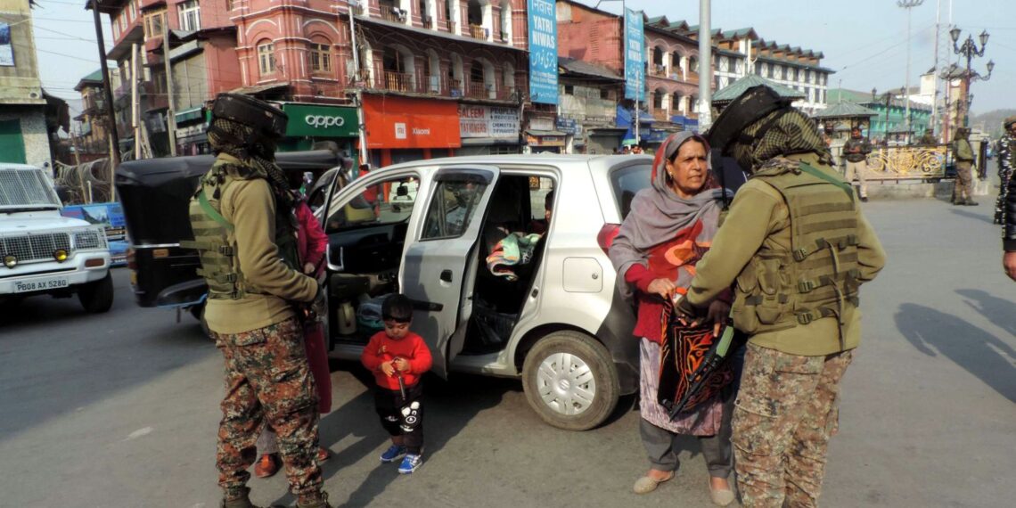 Women paramilitary personnel frisking Kashmiri woman in Srinagar
