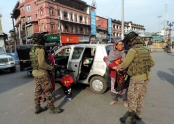 Women paramilitary personnel frisking Kashmiri woman in Srinagar