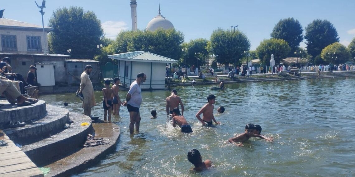 Amid sweltering hot weather conditions children taking bath in the waters of iconic Dal Lake at Hazratbal in Srinagar