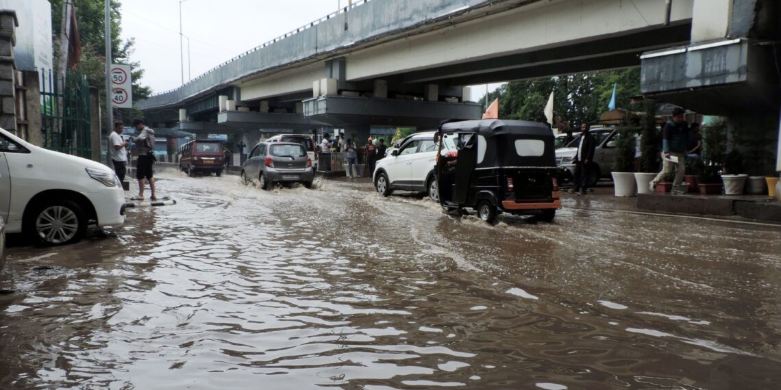 Vehicles passing through a water logged TRC road in Srinagar